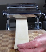 Rolling dough through pasta machine