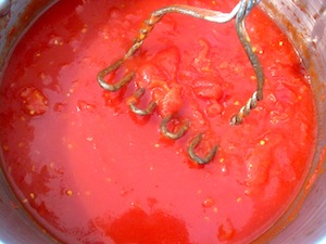 Crushing the tomatoes for the Marinara sauce